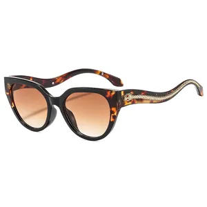 Lunettes de soleil œil de chat, monture écaille, verres dégradés et détail serpent doré