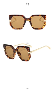 Detail of oversized tortoiseshell sunglasses with brown lenses and golden metal temples