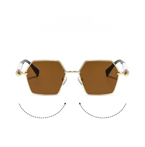 Detail of gold polygonal metal frame sunglasses with brown lenses and ball temple accents