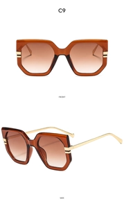 Macro detail of amber oversized hexagonal sunglasses with thin gold metal temples