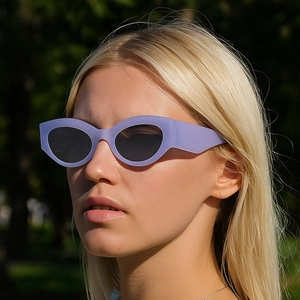 Outdoor close-up of light purple cat eye sunglasses with matte frame on female model