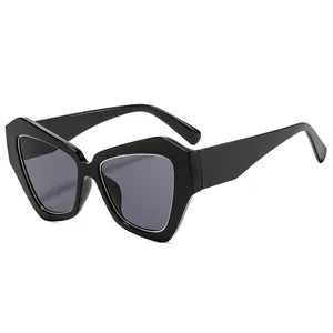 Occhiali da sole geometrici cat-eye oversize con montatura nera e lenti grigio scuro