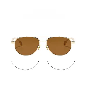 Detail of double bridge aviator sunglasses with gold metal frame and brown lenses