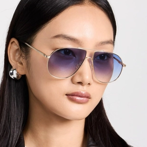 Fashion aviator sunglasses with gold metal frame and gradient blue lenses on a model