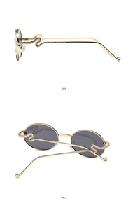 Detail view of gold snake-shaped metal temples and gray oval lenses of trendy Y2K sunglasses