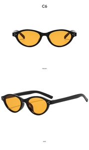 Detail view of oval retro sunglasses with orange lenses and decorative silver studs