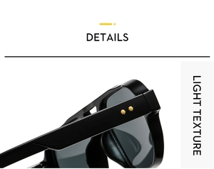 Close-up of black glossy pilot sunglasses with gold star rivets and dark grey lenses