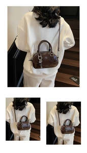 Gros plan d'un sac Boston marron brillant avec breloque clé et logo blanc imprimé