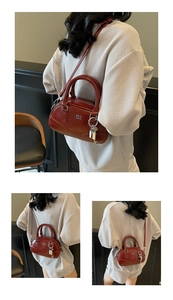 Détail du sac Boston bordeaux montrant le cuir brillant et les ferrures métalliques