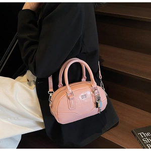 Détail du sac à main Boston rose avec fini brillant, serrure argentée et logo de marque