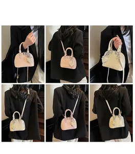 Dettaglio di borse a conchiglia rosa e beige lucide con ciondolo a cuore di perla