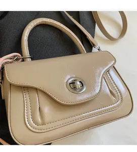 Close-up of a chic apricot PU leather handbag with metallic turn-lock and soft texture
