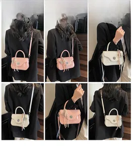 Detail view of mini crossbody handbags with fringe charm and metal clasp closure