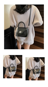 Glossy black leather mini chain bag detail with striped scarf on handle and silver lock