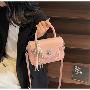 Pink oil wax leather crossbody bag with silver twist lock and tassel charm detail