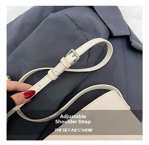 Close-up of adjustable white lychee grain leather shoulder strap with silver buckle