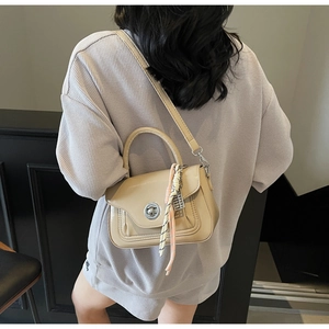 Detail of beige oil wax leather crossbody bag with chic silk scarf and metal buckle