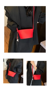 Detailed views of a small red bucket bag with thin strap and silver bear charm