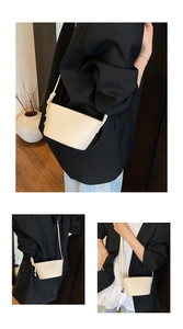 Detail of cream lychee leather handbag with knot strap and silver metal ball charm