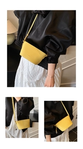 Detailed macro view of yellow lychee grain leather bucket bag with brand lettering