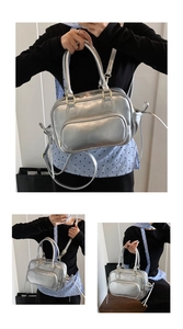 Detail of silver metallic textured handbag featuring glossy finish and double top handles