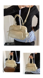 Detail view of beige PU leather Boston bag with zipper pocket and adjustable shoulder strap