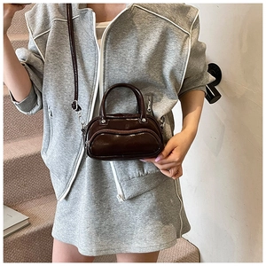Detail of dark coffee glossy leather mini crossbody bag with silver metal hardware