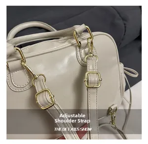 Detail of adjustable detachable shoulder strap with gold metal hardware on beige tote bag