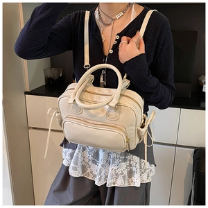 Close-up of cream white PU leather backpack with ribbon bows and multiple zip pockets
