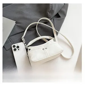 Mini borsa a tracolla in tela bianca accanto a uno smartphone per confronto taglie