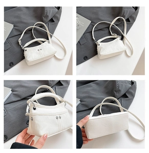 Dettaglio borsa a tracolla in denim bianco con rivetti argentati e design a doppio manico