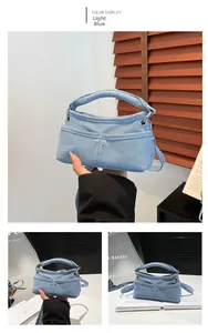 Dettaglio di borsa in denim azzurro con doppie tasche frontali e fibbie in metallo lucido