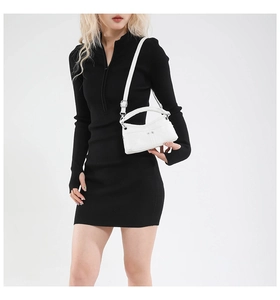Detail view of a white minimalist crossbody bag with adjustable strap and silver rivets