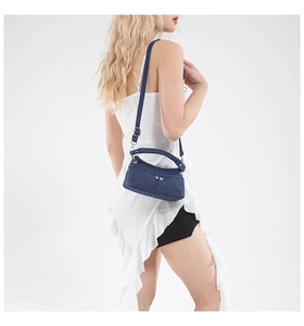 Dettaglio della borsa a tracolla in denim blu scuro con fibbie e cinturino regolabile