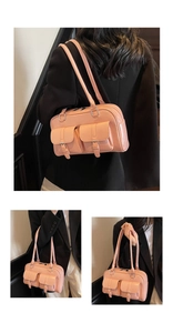 Detail of pink glossy shoulder bag with dual front flap pockets and metallic silver rings