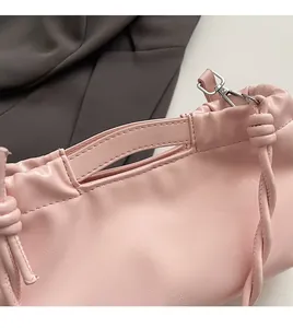 Detail of pink pleated leather bag with silver metallic rings and premium textured finish
