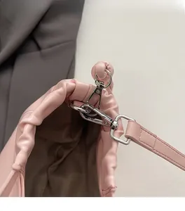 Close-up of premium silver metal buckle and pink leather strap connector on handbag