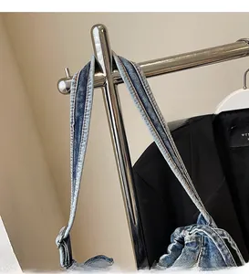 Détail de la bandoulière réglable en denim avec coutures contrastées sur un sac cabas