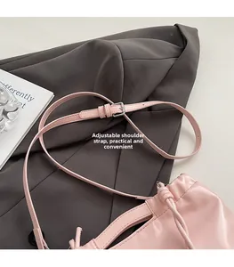 Detailed view of pink crossbody bag featuring an adjustable shoulder strap with silver buckle