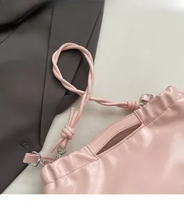Detail of pink ruched shoulder bag showing the knot strap and silver metal hook buckle