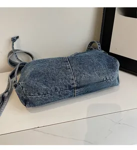 Détail du sac à bandoulière en denim bleu montrant le délavage vintage et les surpiqûres