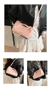 Close-up of pink pleated cloud bag with glossy finish and slim shoulder strap