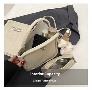 Détail de l'intérieur spacieux du sac à main beige grainé avec sa pochette assortie
