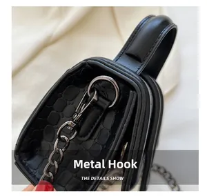 Macro view of gunmetal hardware hook and crocodile pattern texture on black mini bag