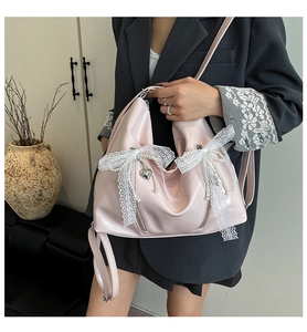 Pink glossy balletcore tote bag with lace bows and pearl charms on model shoulder
