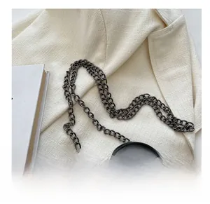 Detail shot of black stone pattern leather mini bag with dark grey metal chain