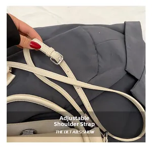 Détail de la bandoulière réglable en cuir crème avec boucle argentée sur le sac