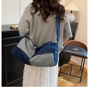 Detail of a large contrast denim tote bag showing stitching and adjustable strap