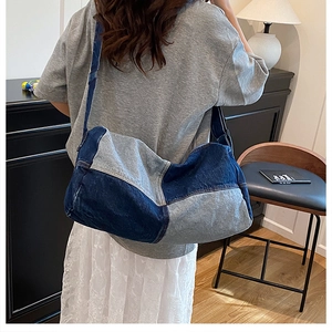 Detail shot of the patchwork denim cylinder bag showing fabric texture and color contrast