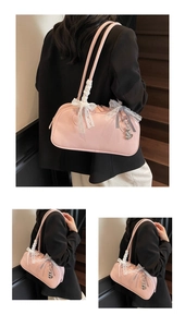 Close-up of pink patent leather bag with lace bow and heart-shaped metal charms